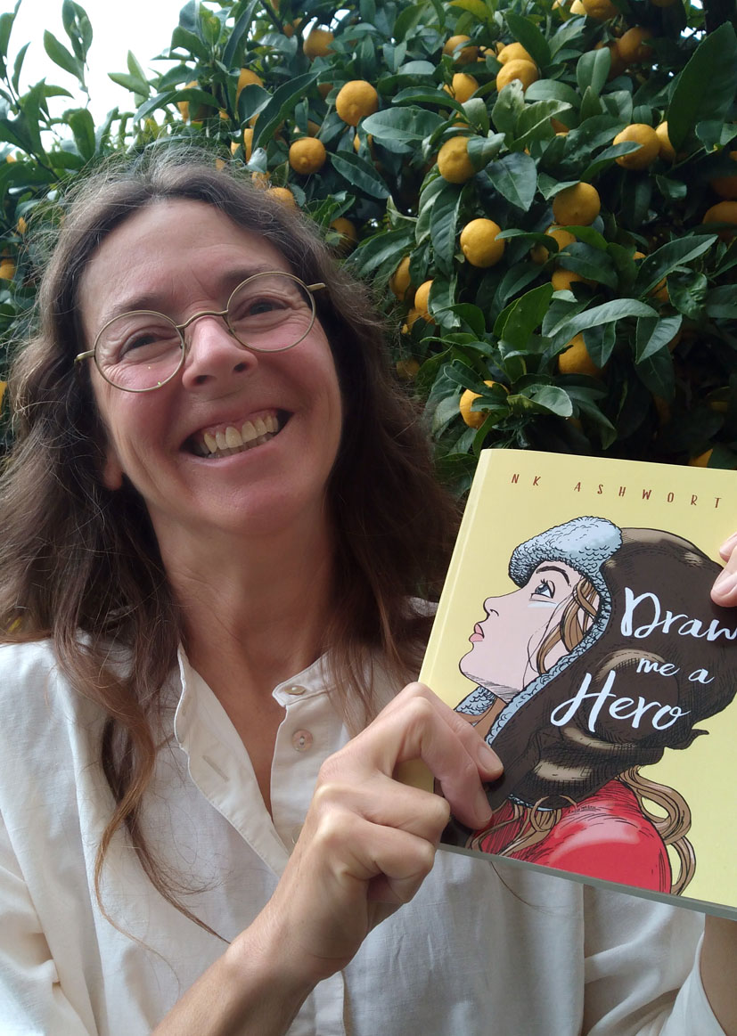 Author NK Ashworth holds a copy of her book Draw Me A Hero