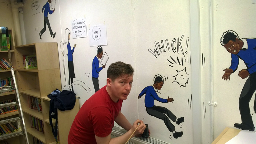 Roger Mason painting a mural in the library at Pilgrim's Way Primary School, SE London